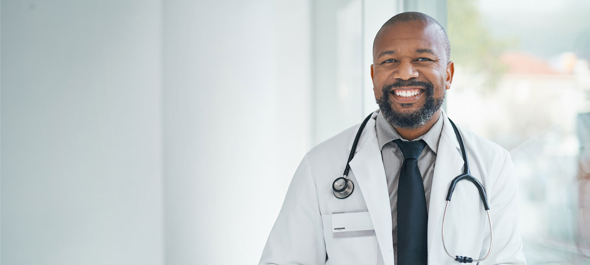 a man wearing a suit and tie smiling at the camera